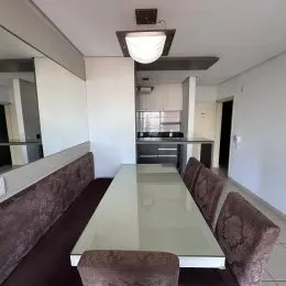 Foto de um ambiente interno com uma mesa longa e teto branco.