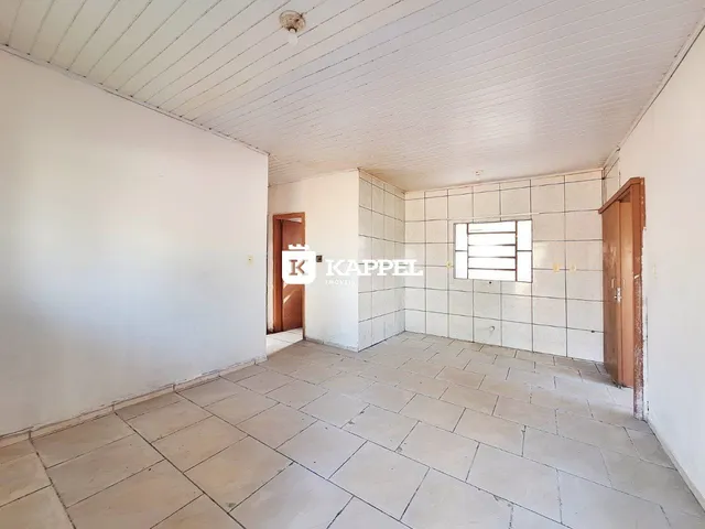 Ambiente interno com piso de cerâmica e paredes brancas em uma residência.