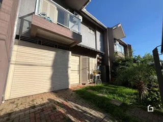 Fachada de uma residência em Lajeado, Brasil, mostrando a garagem e o jardim frontal.