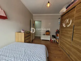 Quarto com cama e armário de madeira em um imóvel no Brasil.