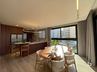 Sala de estar com cozinha e mesa de jantar em um apartamento moderno.