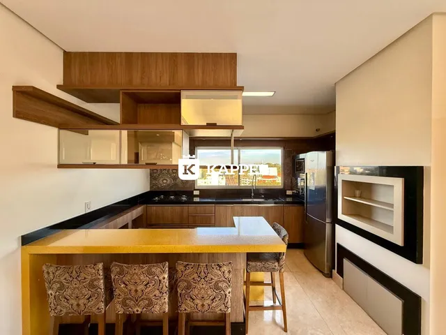 Cozinha moderna com ilha amarela e armários de madeira em um apartamento em Lajeado.