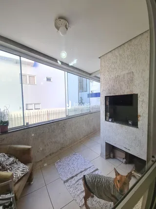 Sala de estar com grandes janelas que dão para a varanda.