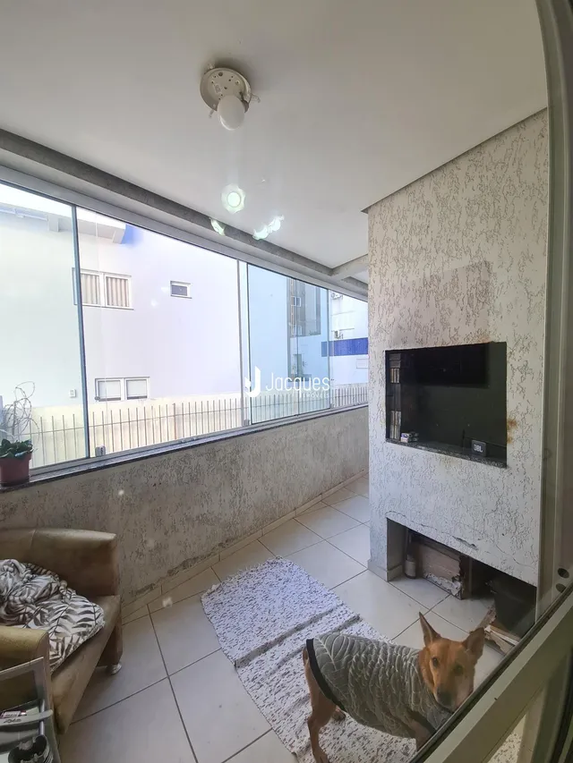 Sala de estar com grandes janelas que dão para a varanda.