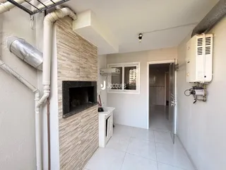 A sala apresenta uma parede de destaque com nicho de lareira e piso de cerâmica.