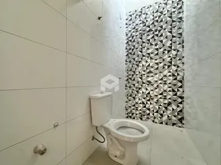 Banheiro com revestimento de azulejos geométricos pretos e brancos.
