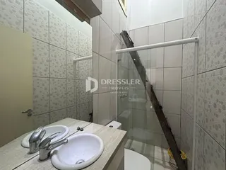 Foto de um banheiro com revestimento de cerâmica e box de vidro.