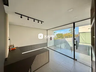 Sala de estar moderna com bancada e porta de vidro que dá acesso a uma área externa.