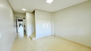 Corredor interno de uma residência com piso de cerâmica clara.