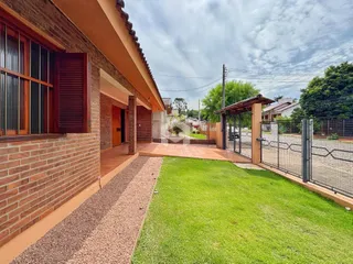 Fachada de uma residência em Lajeado, Brasil, com jardim gramado e cerca.