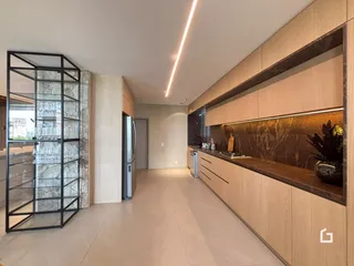 A cozinha moderna apresenta armários de madeira e bancadas escuras.