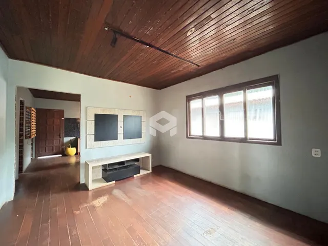 Interior de uma sala com piso de madeira e teto de madeira.