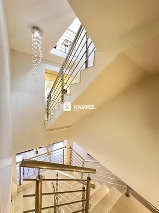 Escadaria moderna com guarda-corpo metálico em um interior de apartamento.