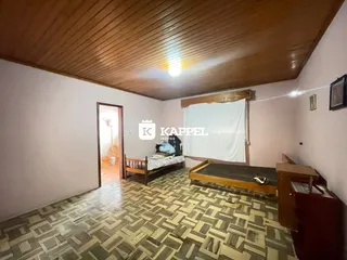 Quarto com cama de madeira e piso de ladrilhos no imóvel.