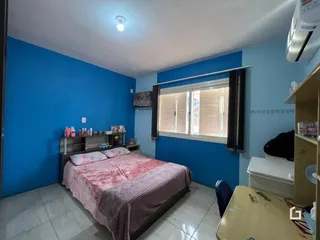Quarto com paredes azuis e cama de casal em um imóvel no Brasil.