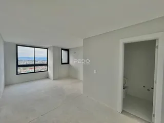 Interior de um ambiente com janela e porta de acesso a um banheiro.