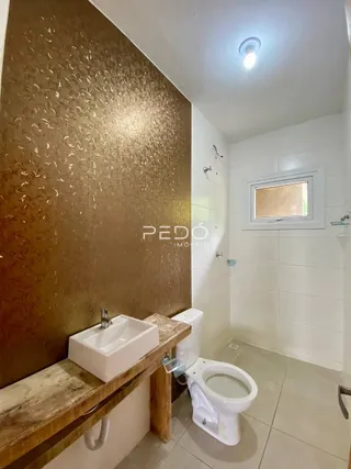 Foto de um banheiro com revestimento de cerâmica e bancada de madeira.