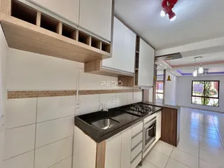 Foto de uma cozinha moderna com armários brancos e bancada escura.