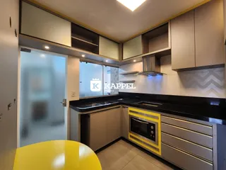 Cozinha moderna com armários e bancada escura.
