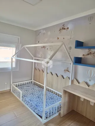 Quarto com cama de madeira e piso de madeira clara.