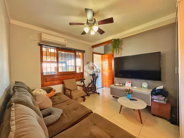 Sala de estar com sofá e televisão em um imóvel no Brasil.