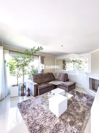 Sala de estar iluminada com sofá grande e decoração moderna em um apartamento.