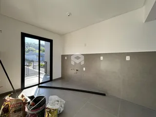 Interior de um ambiente com piso de cerâmica e parede de concreto aparente.