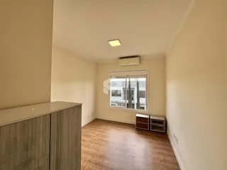 Foto de um ambiente interno com piso de madeira e parede clara.