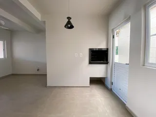 Sala de estar com piso claro e lareira em ambiente interno.