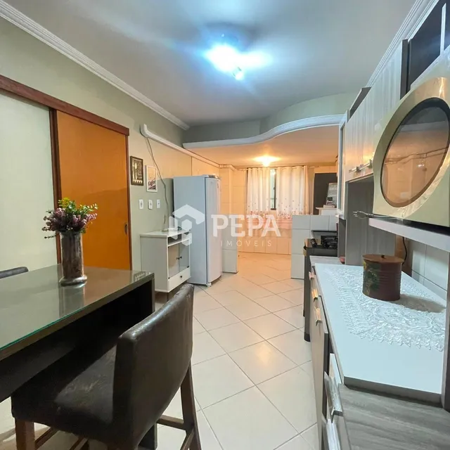 Cozinha com armários brancos e piso de cerâmica claro.