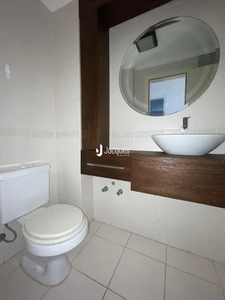 Banheiro com piso de cerâmica e bancada de madeira.