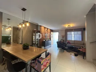 Sala de jantar e estar com piso claro e parede de madeira na residência.