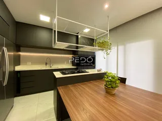 Foto de uma cozinha moderna com armários escuros e bancada clara.