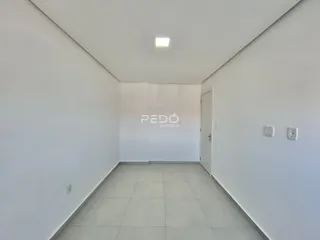 Corredor interno de um imóvel com paredes brancas e piso claro.