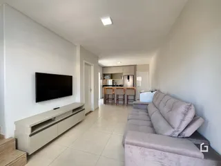Sala de estar moderna com sofá e televisão em um apartamento.