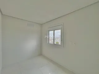 Um cômodo vazio com paredes brancas e uma janela.