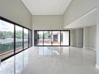 Sala de estar ampla com grandes portas de vidro que dão para o exterior.