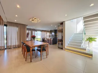 Ambiente interno amplo com mesa de jantar de madeira e área de estar.