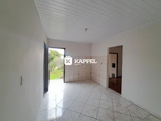 Hall de entrada com piso de porcelanato claro e acesso ao jardim externo.