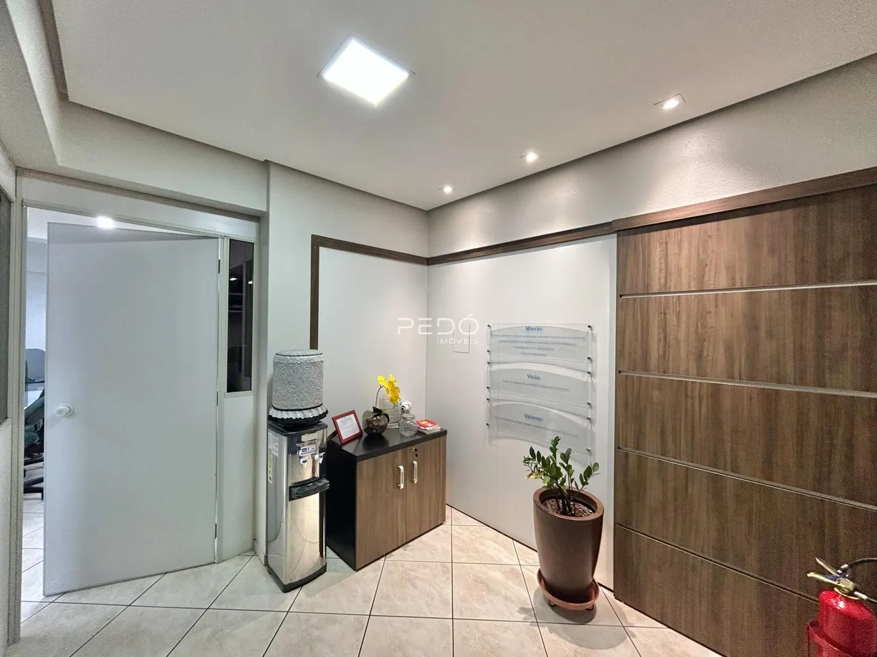 Interior de um corredor com revestimento de madeira e portas brancas.