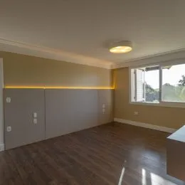 Ambiente interno com piso de madeira e iluminação clara.