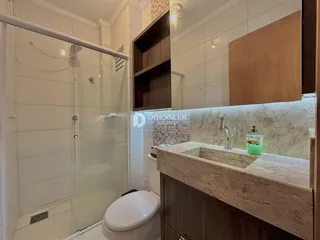 Foto de um banheiro com box de vidro e bancada de mármore.