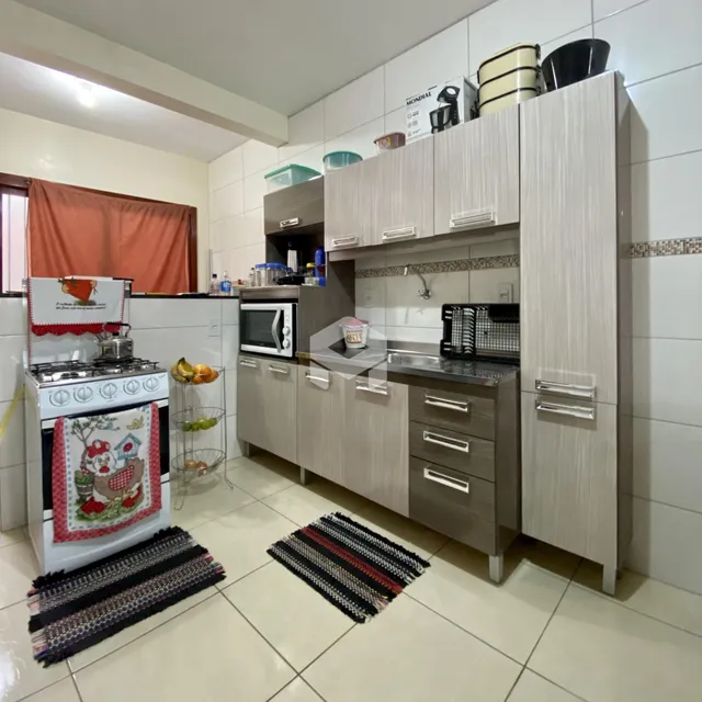 A cozinha apresenta armários modernos e piso cerâmico.