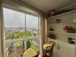 Vista da sala de estar com grande janela para a paisagem urbana.
