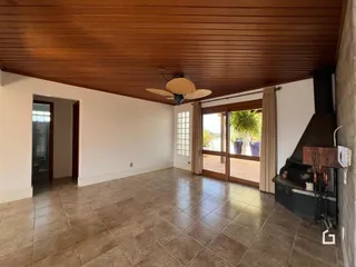Sala com piso de cerâmica e teto de madeira.