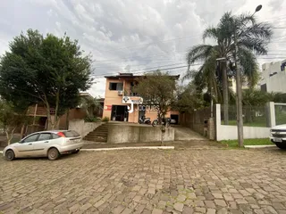 A fachada de uma residência em Lajeado, Brasil, com jardim e estacionamento.