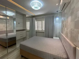 Quarto com cama e portas de vidro em um apartamento.