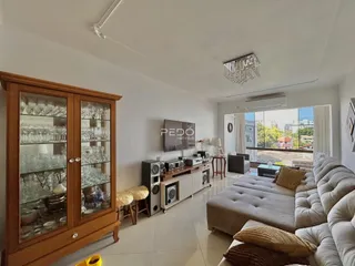 Sala de estar com sofá e armário de madeira em um imóvel no Brasil.