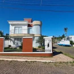 Fachada de uma casa residencial em Lajeado, Brasil, com revestimento branco e detalhes em terracota.