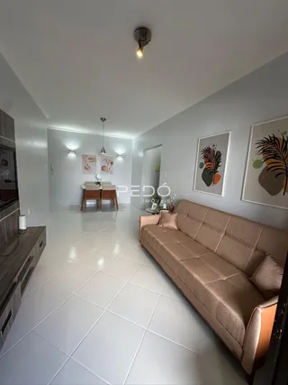 Sala de estar com piso branco e sofá bege em um imóvel no Brasil.